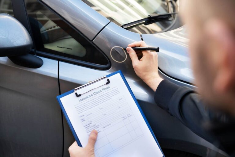 Mann macht Schadenaufnahme am Auto